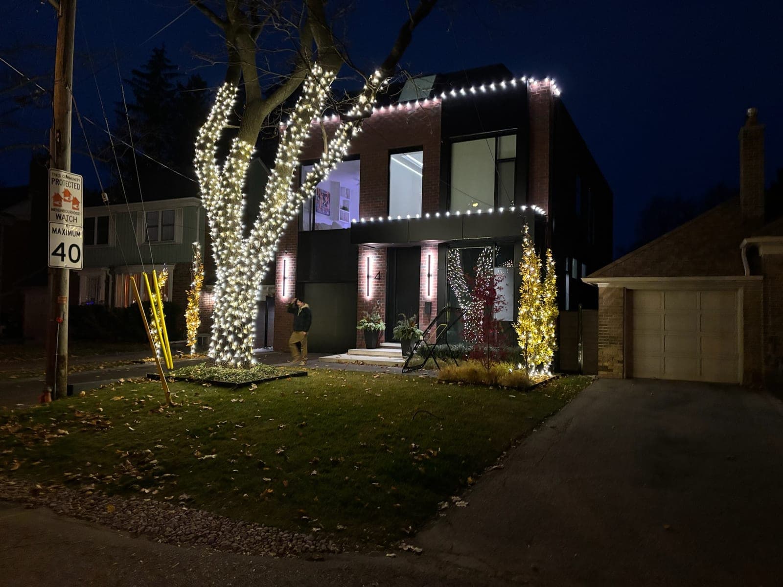 Crew member removing commercial-grade C9 rooflines from a Hamilton home in a boom lift after the holidays