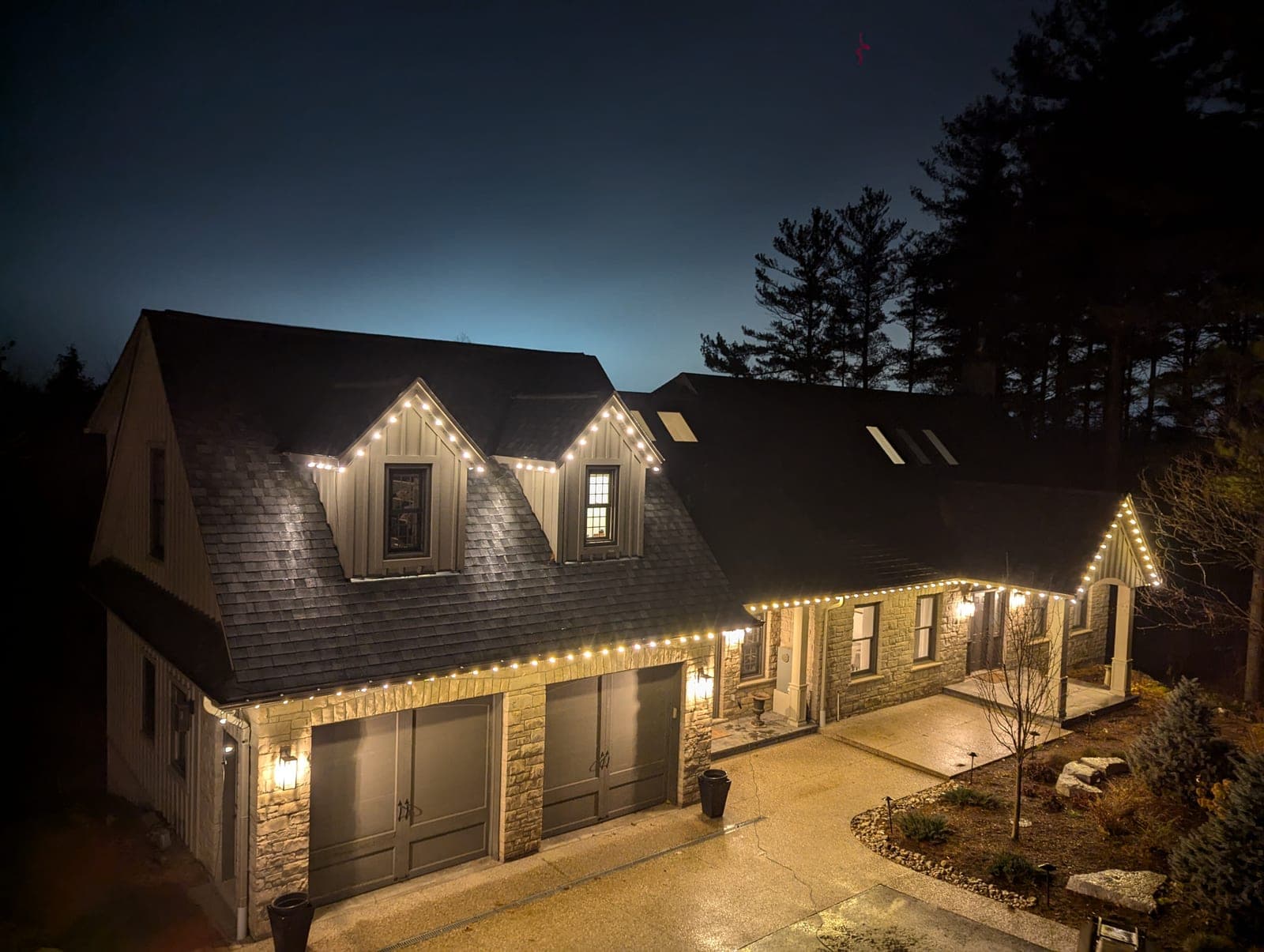 Two-storey Hamilton area home with warm white C9 roofline lighting installed by a professional crew at dusk